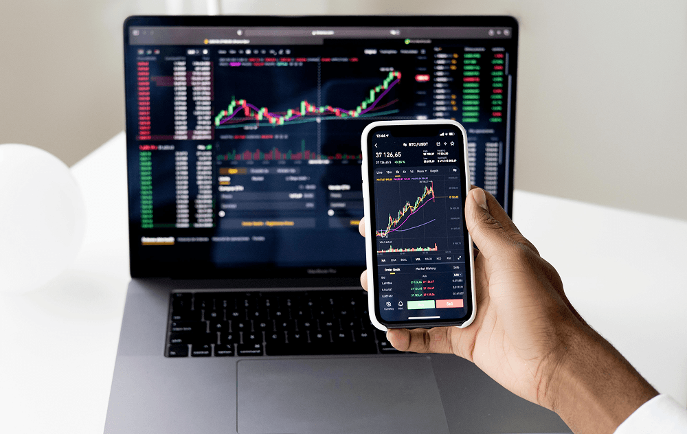 Financial trading dashboard on a laptop and phone
